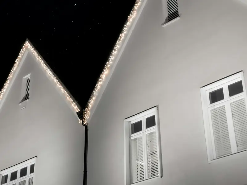 White gables outlined in crisp white lights at night