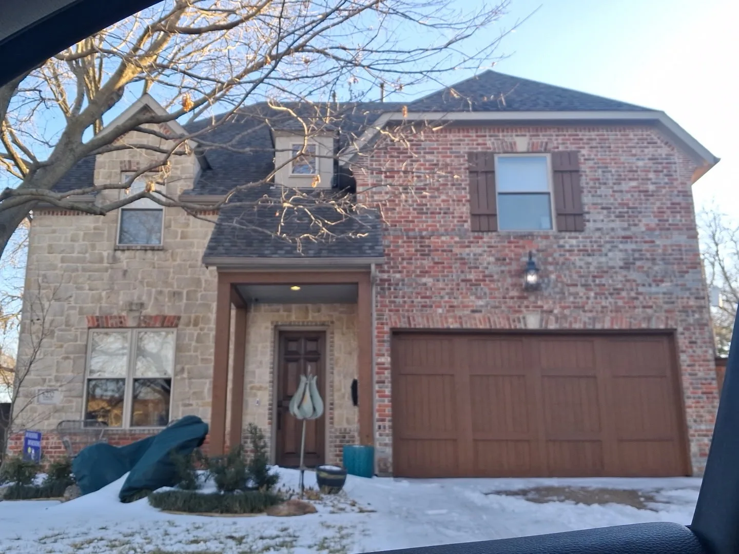 Front elevation of a two-story brick-and-stone Bethany Lakes home in Allen after a full 18-window replacement