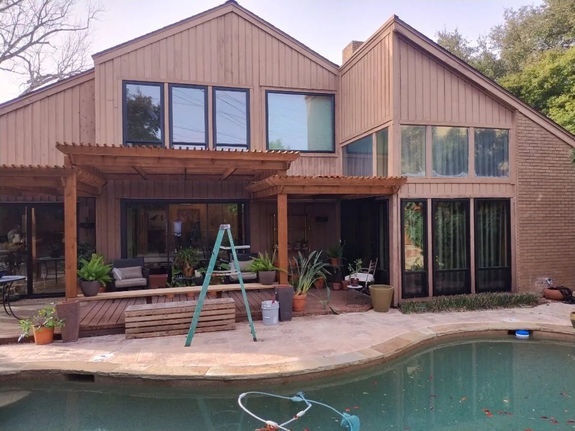 Rear elevation of a Stonebridge Ranch contemporary cedar home after a full 28-window bronze ProVia Endura replacement